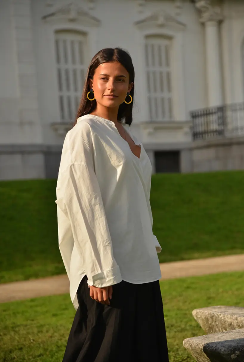 Modelo con camisa blanca y pendientes artesanales de aro amarillo